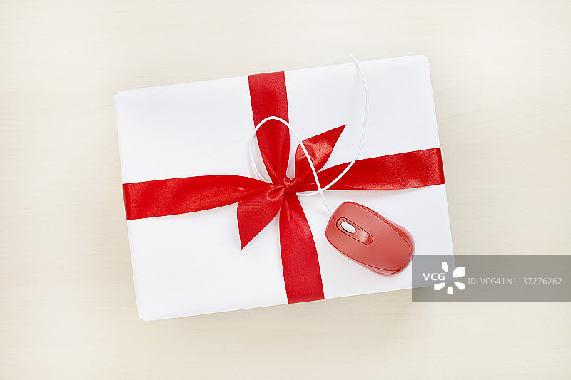 白色包装的礼物和红色电脑鼠标的静物，象征着网上购物图片素材