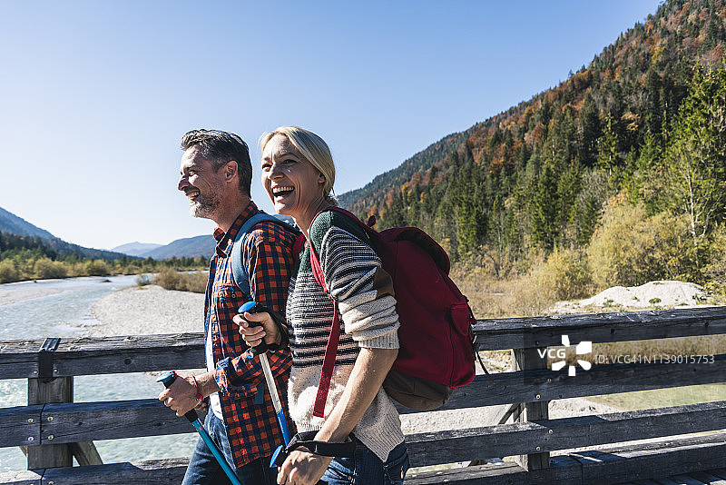 奥地利，阿尔卑斯山，幸福的夫妇在徒步旅行过一座桥图片素材