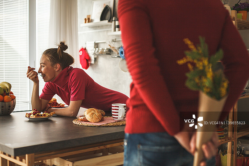 年轻女子在厨房柜台上吃早餐图片素材