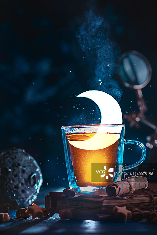 半月形茶杯。双层墙玻璃和一个闪闪发光的月牙。神奇的茶概念与复制空间图片素材