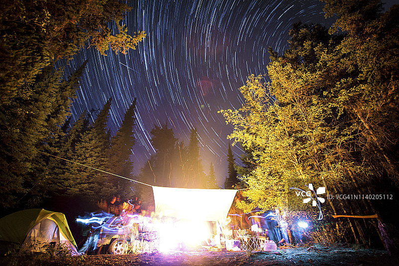 加拿大不列颠哥伦比亚省，纳拉玛塔，埃莉诺湖休闲区，夜空中长时间曝光的星星和围绕篝火的光迹图片素材
