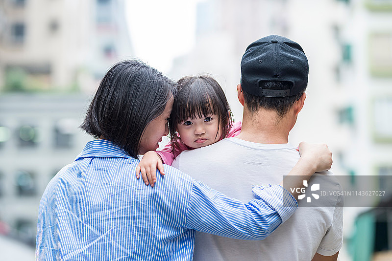 一个亚洲三口之家走在香港街道上图片素材