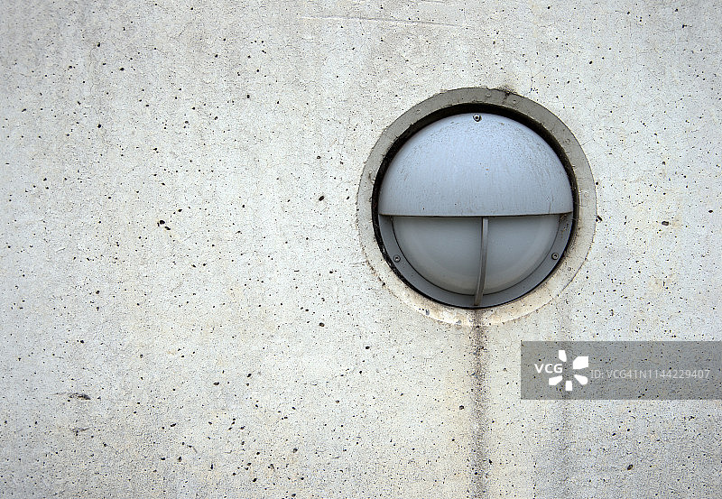 圆形户外灯安装在混凝土周围的墙壁上图片素材