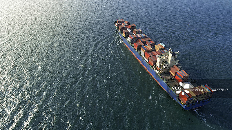 鸟瞰图集装箱船在海上与阳光物流，进出口，航运或运输。图片素材