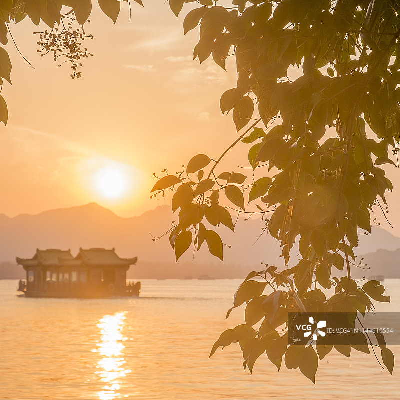 日落时分，一艘游船驶过杭州西湖。图片素材