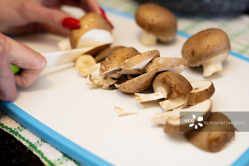 在切菜板上切蘑菇的女人图片素材