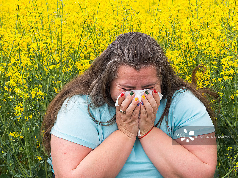 一个对花粉过敏的女人打喷嚏的肖像图片素材