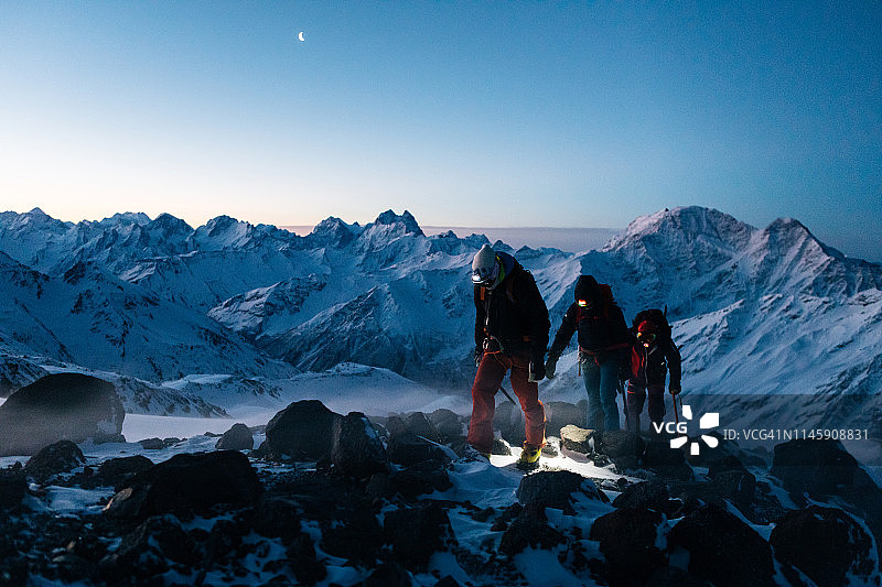 登山队员在暮色中向山顶进发图片素材