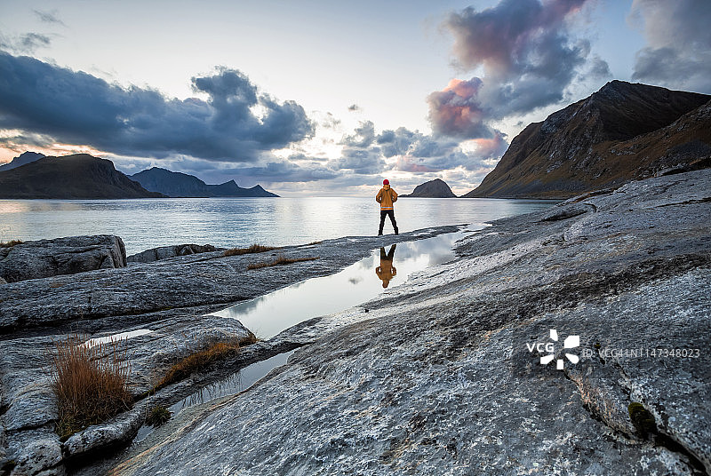 挪威，罗浮敦群岛，霍克兰海滩，徒步者站在岩石上图片素材