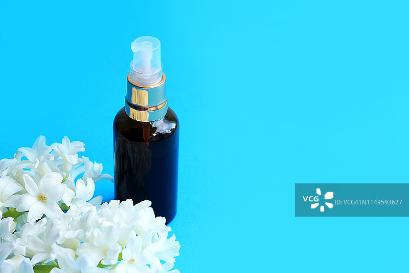 瓶子化妆品与花在蓝色的背景图片素材