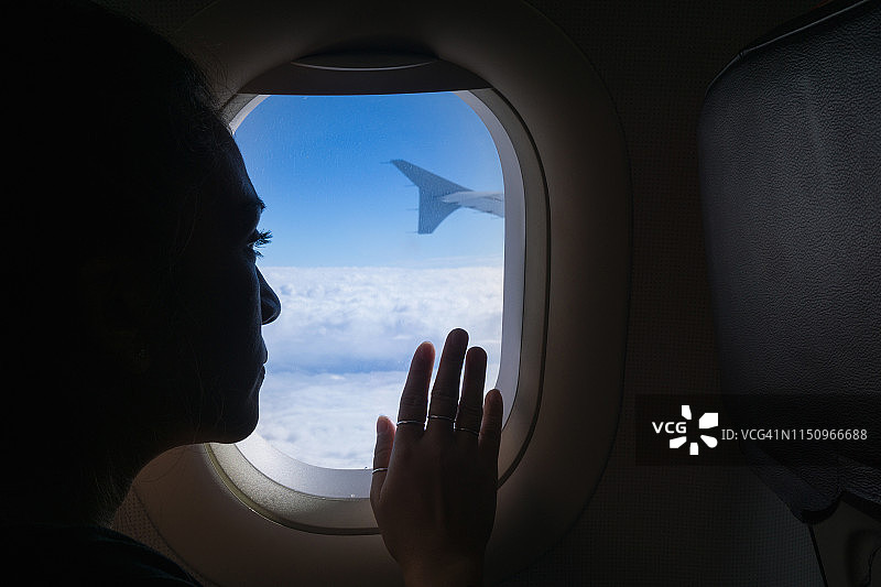 坐飞机的女人望着窗外图片素材