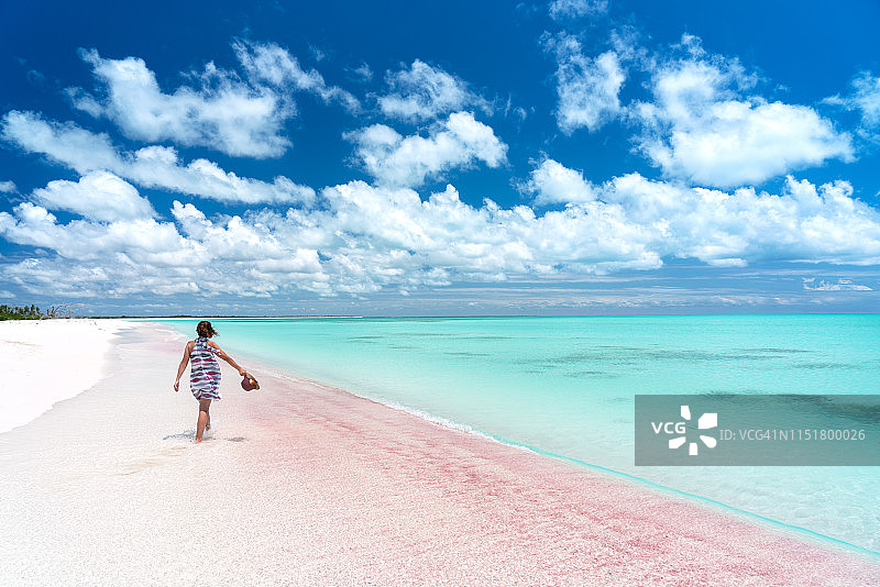 在加勒比海，一个女人在浅浅的水晶水中行走图片素材