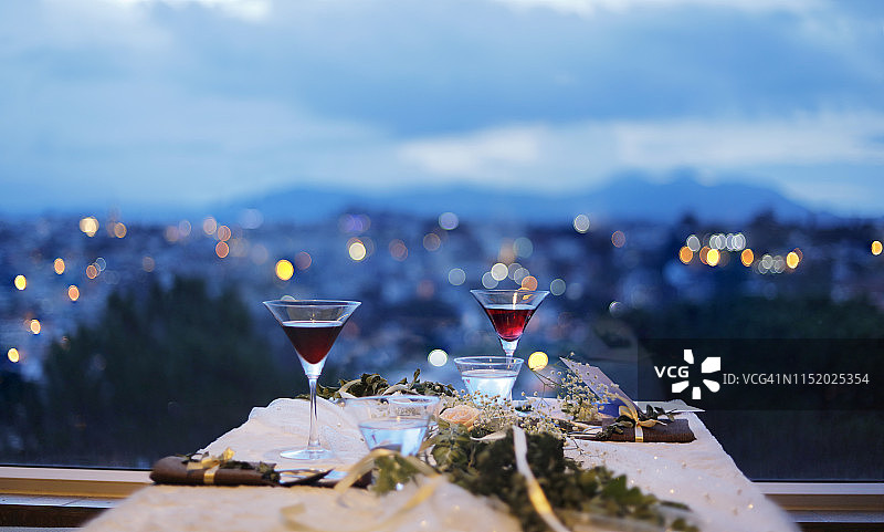 晚上，在城市的背景下，在窗边喝一杯饮料图片素材