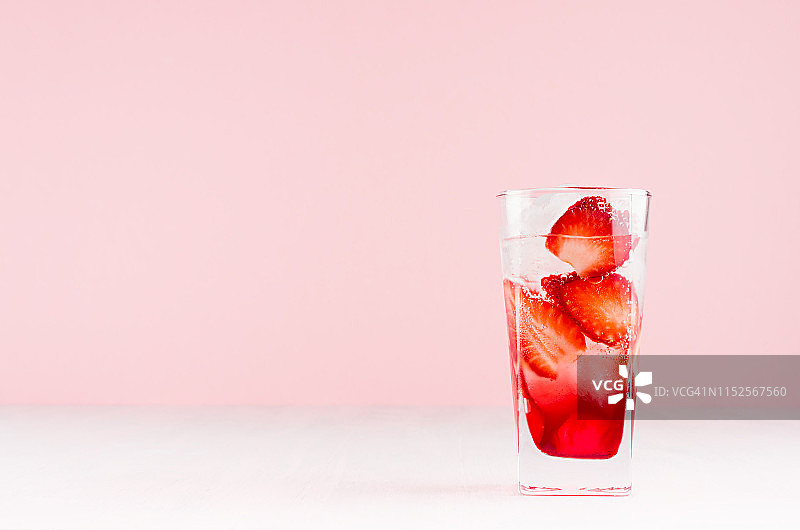 夏日新鲜草莓鸡尾酒与红酒，草莓片，冰块在柔和的粉红色背景，复制空间。图片素材