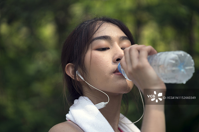 一个年轻女子喝冷水的照片图片素材