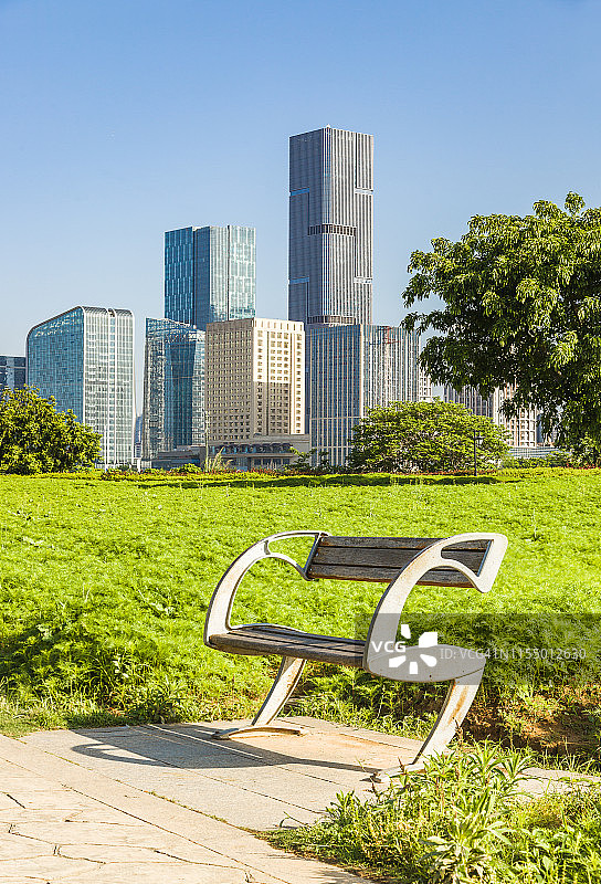 日出时的公园长椅，以城市景观为背景图片素材