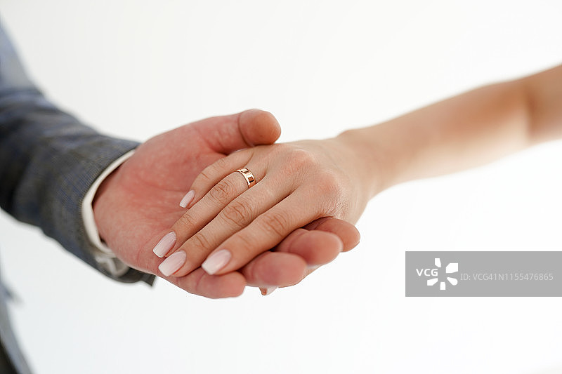 牵手与结婚戒指在白色背景与拷贝空间。爱情和婚姻的概念图片素材