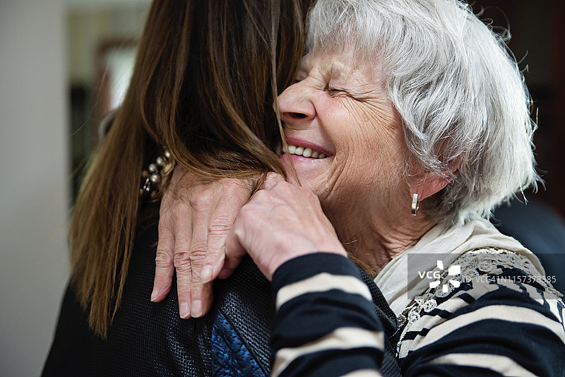 年长的祖母和成年的孙女拥抱。图片素材