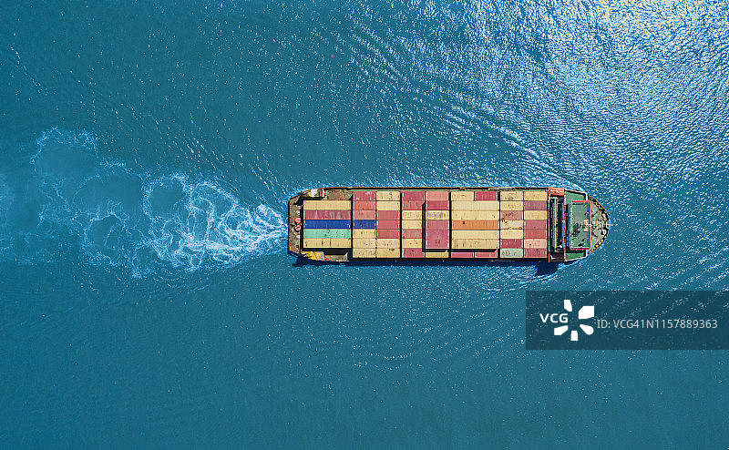鸟瞰图小集装箱船全承运人在蓝色的海上物流，进出口，航运或运输。图片素材
