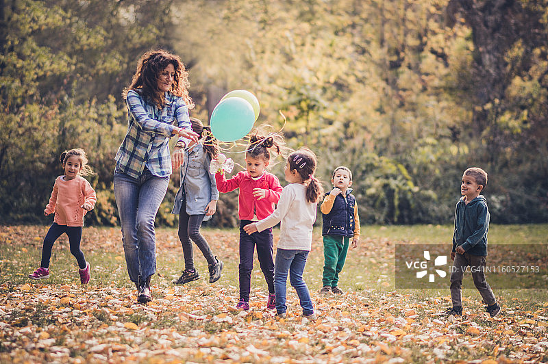 一群快乐的孩子在一个秋天的公园里玩耍图片素材
