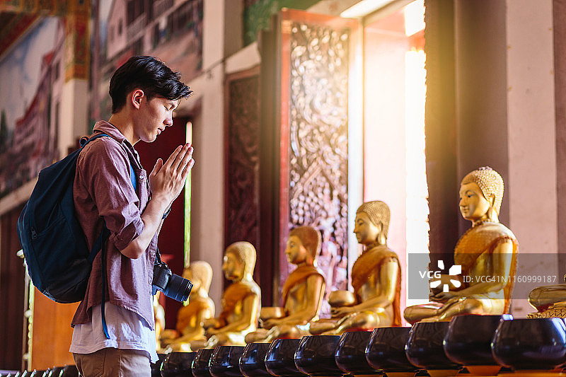 年轻的亚洲旅行家男子旅行背包尊重或祈祷Wat Nong Waeng庙，孔敬，泰国图片素材