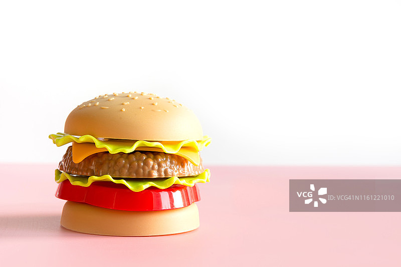塑料汉堡，沙拉，粉红番茄。图片素材