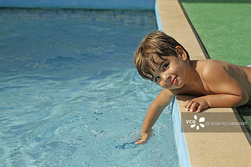 小男孩使游泳池的水泛起涟漪图片素材