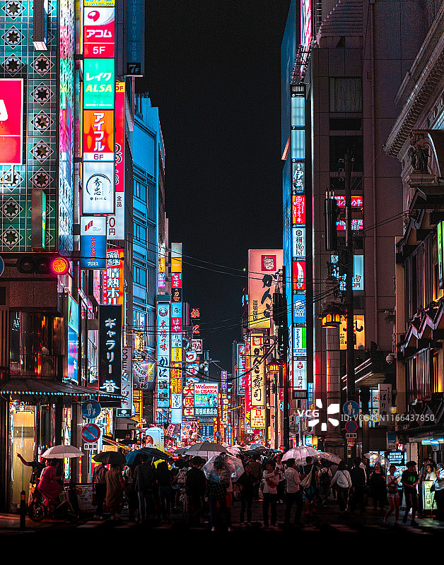 在大阪，人们撑着雨伞走在人行横道上图片素材