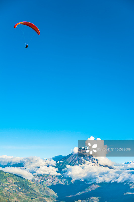 在厄瓜多尔安第斯山脉顶端飞行的滑翔伞教练和游客图片素材