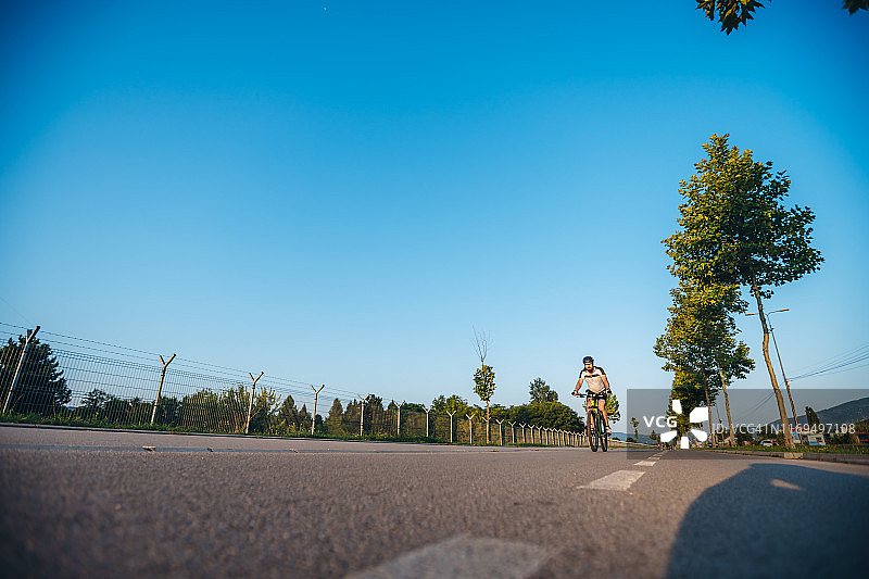 骑自行车的人在日落大道上图片素材