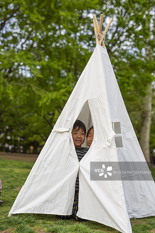 在公园里的帐篷里玩耍的亚洲儿童图片素材