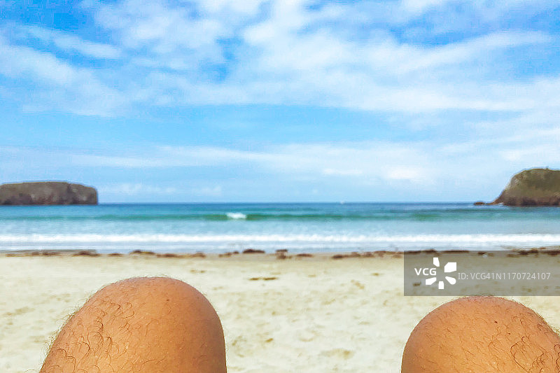 西班牙北部兰尼斯市托里姆比亚市的裸体海滩上，一名男子的膝盖。图片素材
