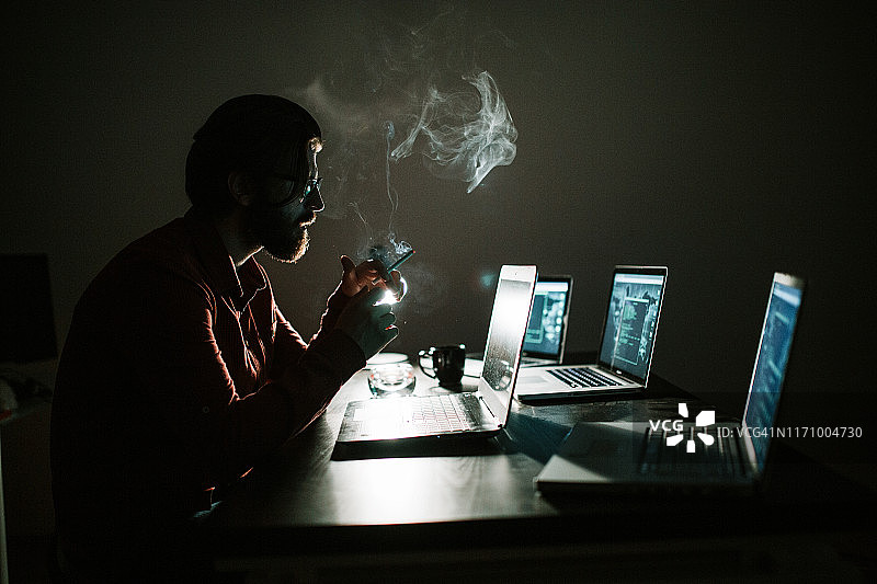 黑客用电脑在暗室里工作图片素材