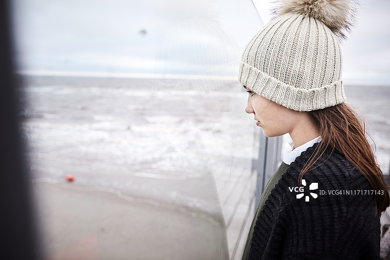 女孩戴着针织帽在海边图片素材