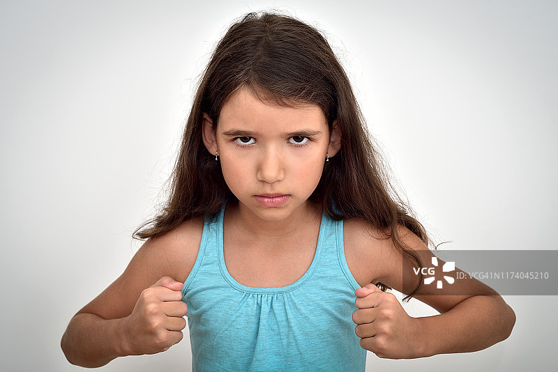 愤怒和好斗的年轻女孩握紧拳头图片素材
