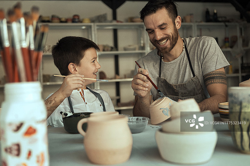 父亲和儿子在画陶器图片素材