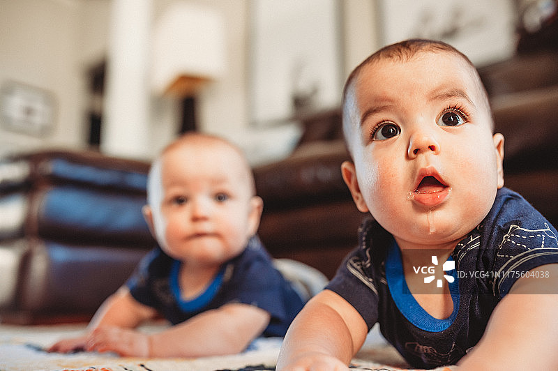 胖乎乎的6个月大的双胞胎在做俯卧时间的时候一起玩图片素材