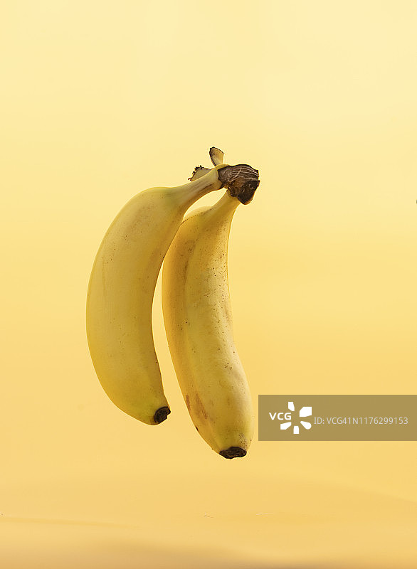 黄色背景上的两根香蕉图片素材