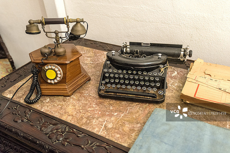 桌上放着老式打字机和电话图片素材