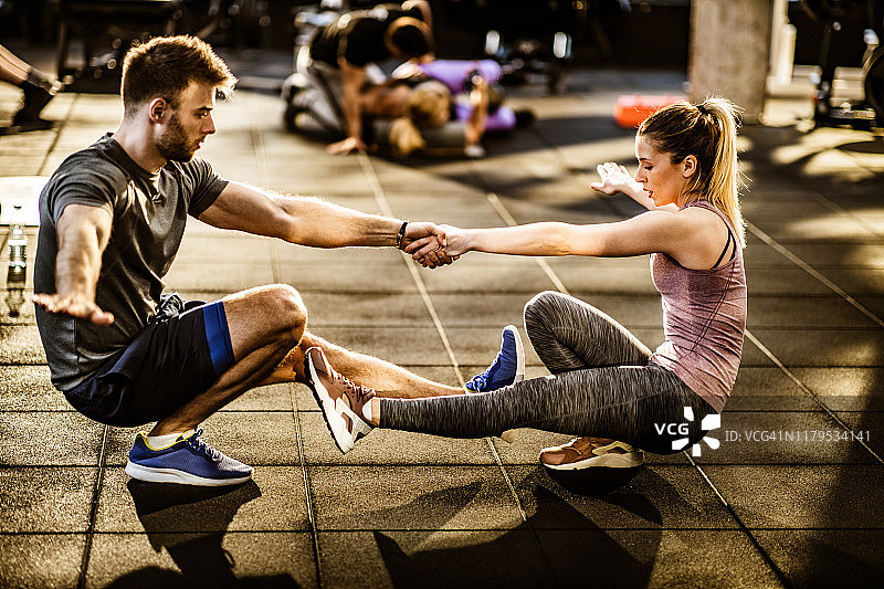坚定的运动情侣在健身房进行平衡练习。图片素材
