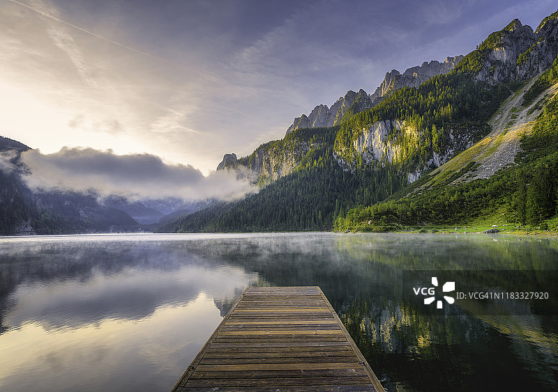 奇异的日出与雾湖在蔚蓝的高山湖泊Vorderer Gosausee。上奥地利哥绍山谷图片素材