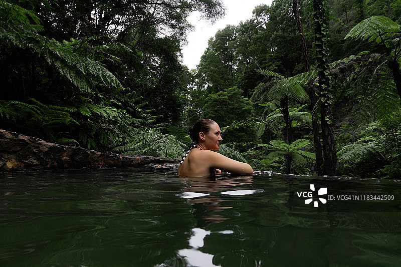 女子在亚速尔群岛热带雨林中享受天然温泉。图片素材