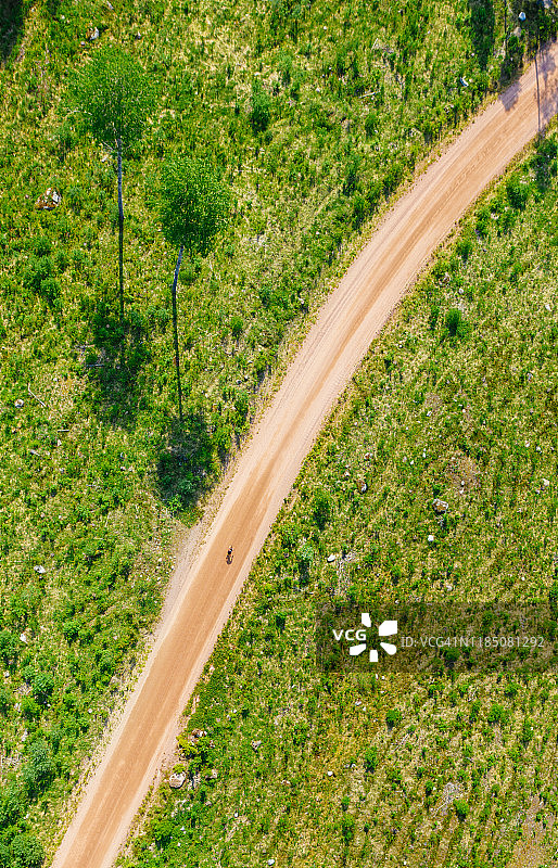 从上至下的鸟瞰图的乡村道路与一个单独的自行车在芬兰图片素材