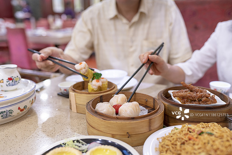 亚洲夫妇拿起筷子点心和享受各种各样的中国点心在餐厅图片素材