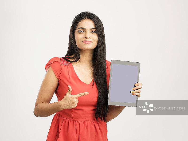 忧心忡忡的印度年轻女子展示数字平板电脑图片素材