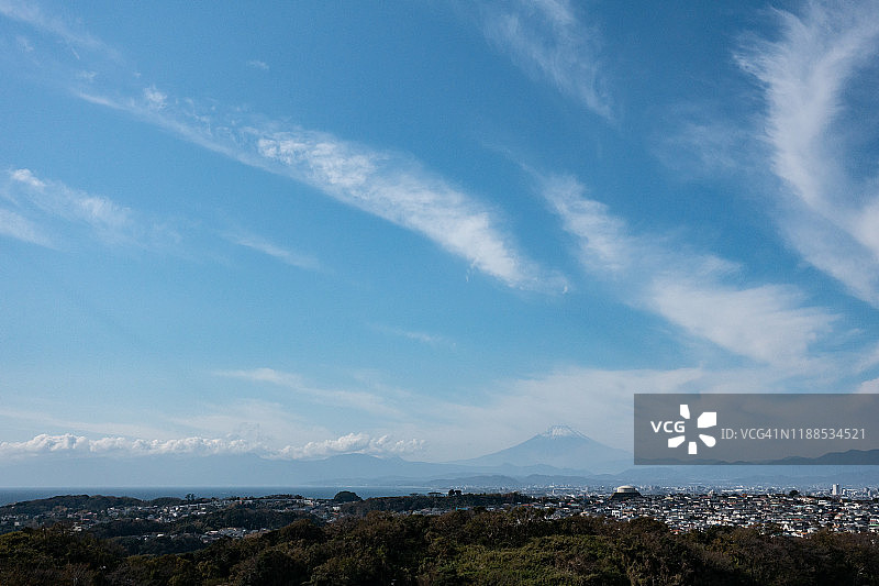 白雪皑皑的富士山和日本神奈川县海边的住宅区图片素材