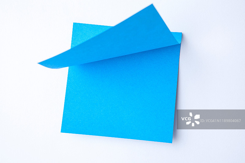 空白蓝色纸便条垫提醒贴在软木白板上。文本的空白。办公设备。图片素材
