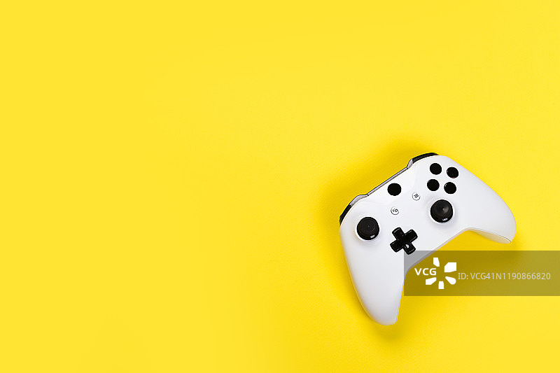游戏手柄孤立在黄色背景上，视频游戏机开发互动娱乐图片素材