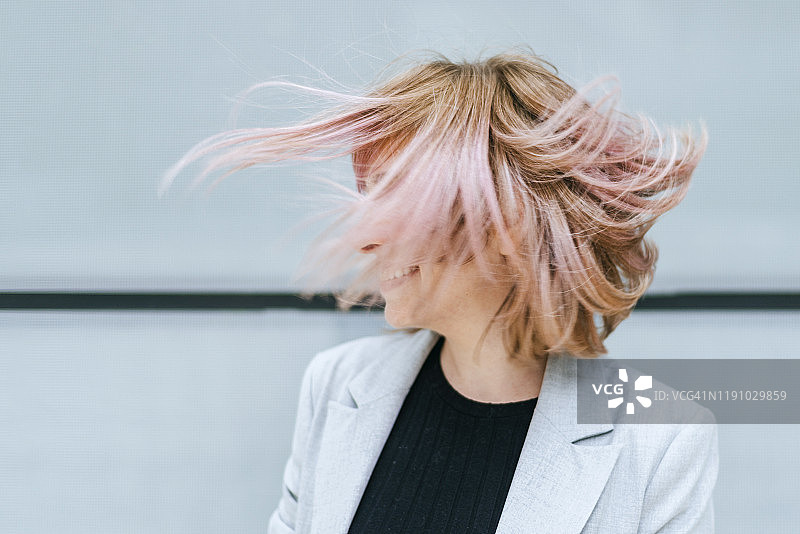 女人撩动着她粉红色的头发图片素材