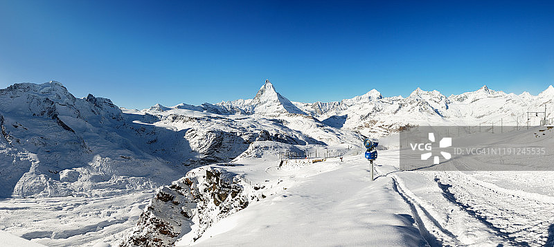雪山全景照片，与顶部的马特洪峰在中心。准备冬季滑雪场，为圣诞节期间。山坡边有新雪。图片素材